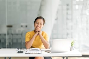 Focused Indian woman using laptop at home, looking at screen, chatting, reading or writing email